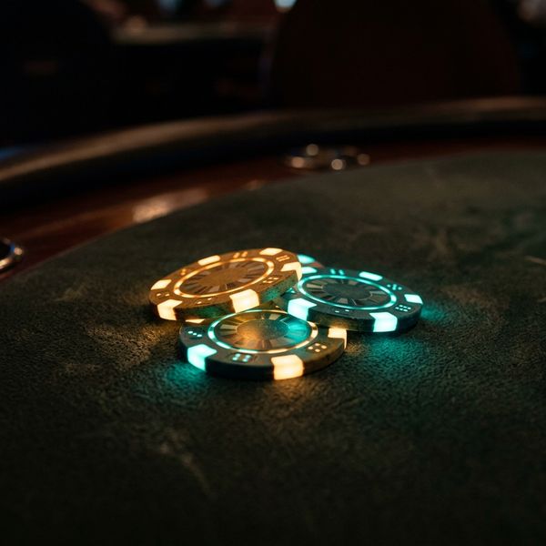 Glowing casino chips stacked on dark felt table